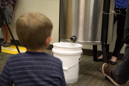 Young Co-op member watches solar honey flow